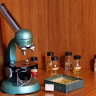 Оригинальный старинный микроскоп с набором образцов микромира и реактивов для проведения лабораторных исследований.