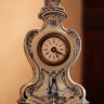 Антикварные настольные кабинетные часы с будильником, в корпусе из Делфтского фарфора (нидерл. Delfts blauw, фарфор в сине-белых цветах, производившийся в городе Делфт, Нидерланды). Часы произведены в конце 19 - начале 20 века в стиле «Картель» в форме Ви
